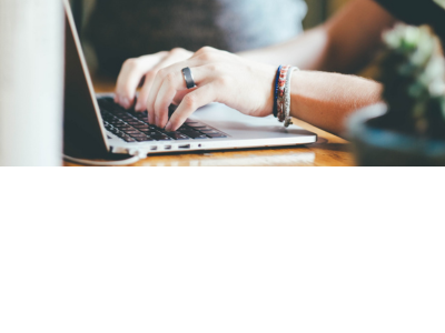 An individual typing on a laptop